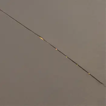Minimalist Fishing Line with Floating Yellow Dots on concrete