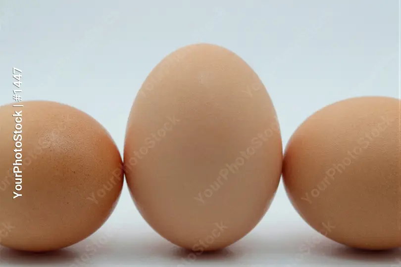 Three Different Sized Light Brown Eggs Arranged Triangularly