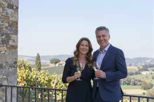 Man and Woman Smiling at Camera Overlooking Vineyard