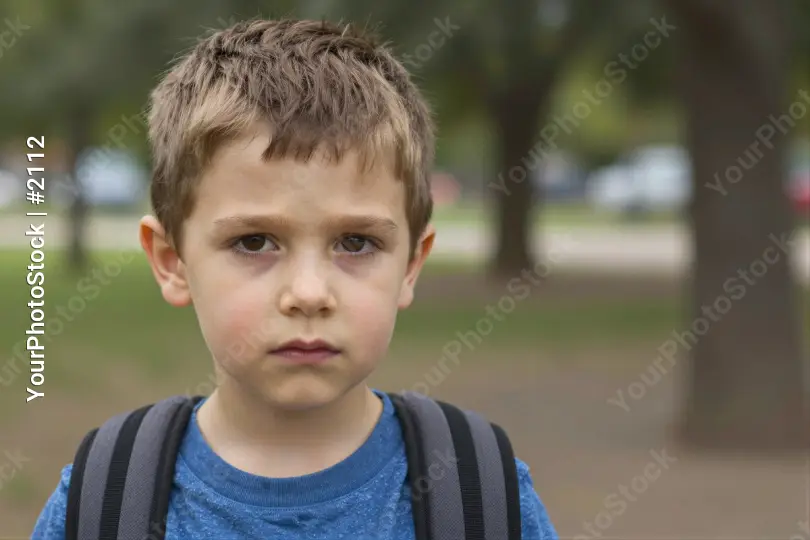 Young Boy in Park Looking Serious serious expression kid student