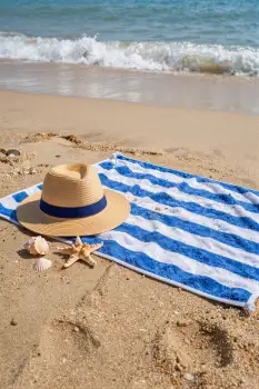 Beach Scene with Striped Towel and Seashells straw hat