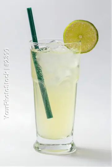 Tall Glass Filled with Yellow Drink and Lime Slice