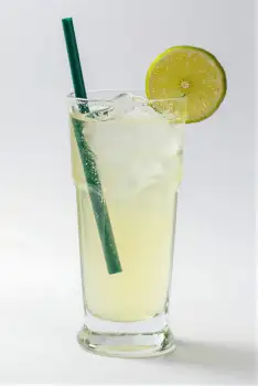 Tall Glass Filled with Yellow Drink and Lime Slice