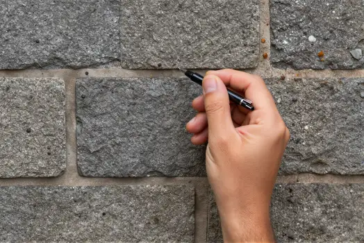Hand Writing on Gray Brick Wall irregular bricks
