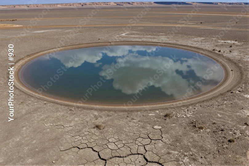 Desolate Circular Puddle in Barren Landscape dry