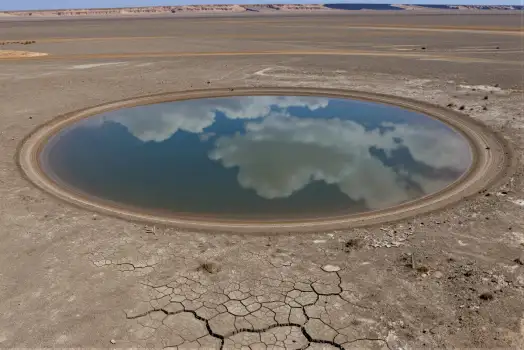 Desolate Circular Puddle in Barren Landscape dry