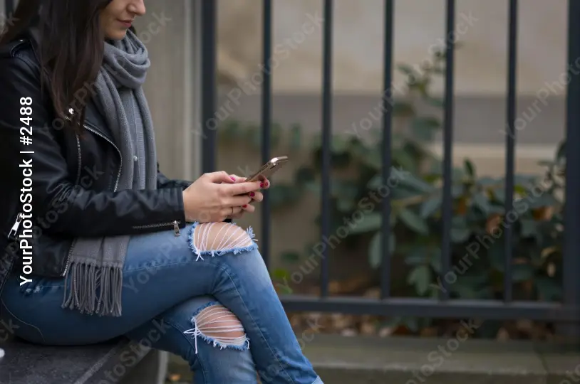 Young Woman Texting on Bench black leather jacket
