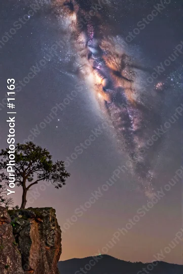 Spiral Galaxy Over Mountain Landscape at Night