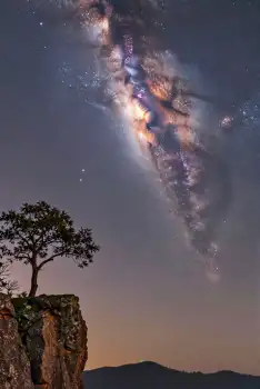 Spiral Galaxy Over Mountain Landscape at Night