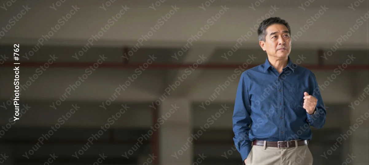 Middle-aged Asian man giving a presentation in an empty room business corporate