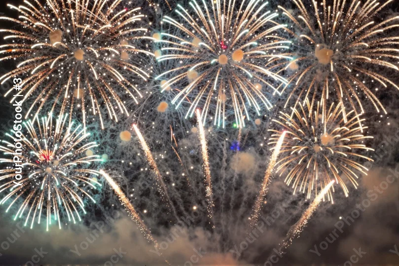 Nighttime fireworks explode over a festive scene.