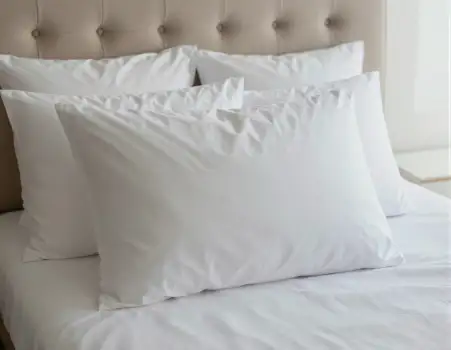 Bedroom with White Sheets and Plush Pillows tufted headboard hotel