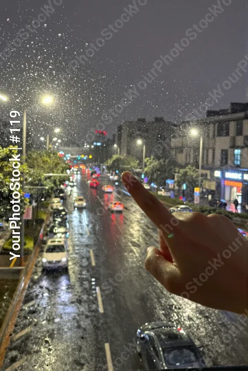 Person Pointing at Busy Night Street with Rain