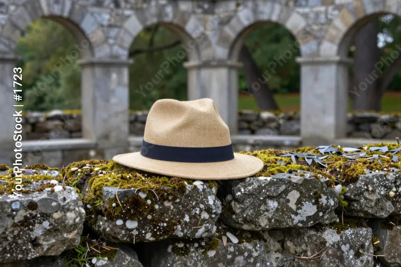 Beige Straw Hat on Mossy Stone Wall old structure