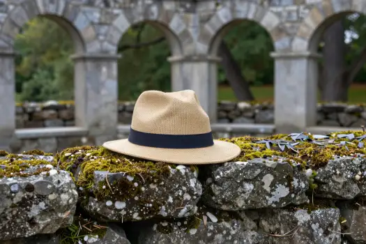 Beige Straw Hat on Mossy Stone Wall old structure