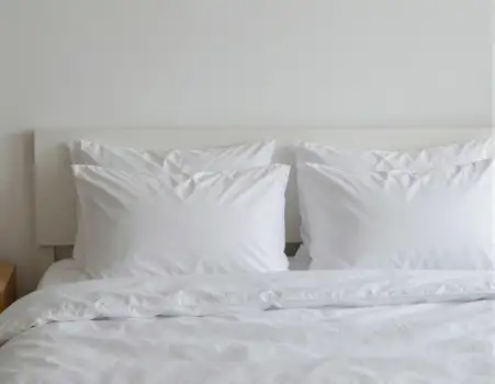 White Bed with Pillows in Minimalist Setting headboard hotel