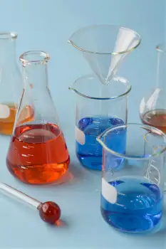 Group of laboratory glassware on light blue background