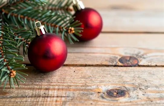 Rustic Christmas Decor with Pine Branches and Ornaments on Wood Background