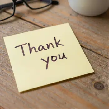 thank you sticky note on desk cursive wooden desk