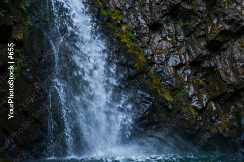 Waterfall cascading over rocky cliff cascade mist