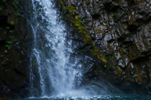 Waterfall cascading over rocky cliff cascade mist