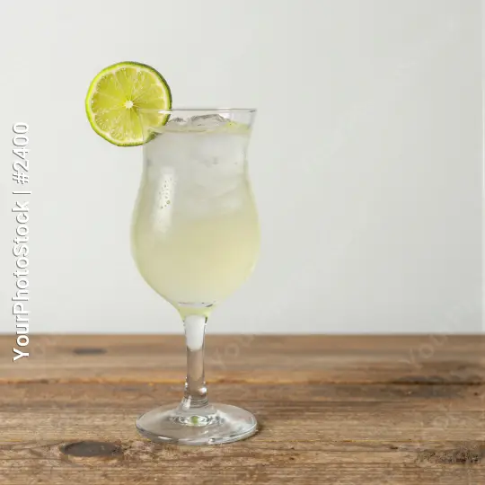 Tall Glass with Light Yellow Margarita on Wooden Surface