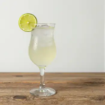 Tall Glass with Light Yellow Margarita on Wooden Surface