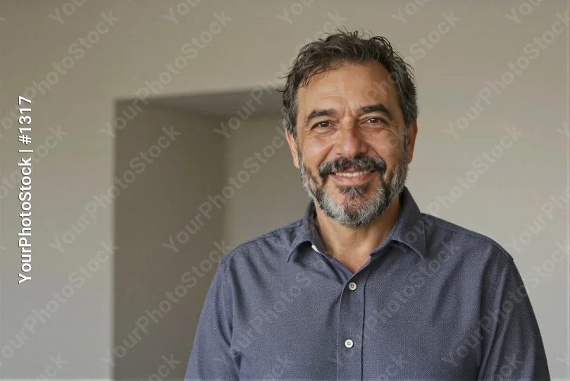 Middle-aged man with beard smiling in an empty room business corporate