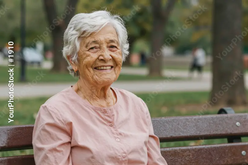 Elderly Woman Smiling on Wooden Bench in Park