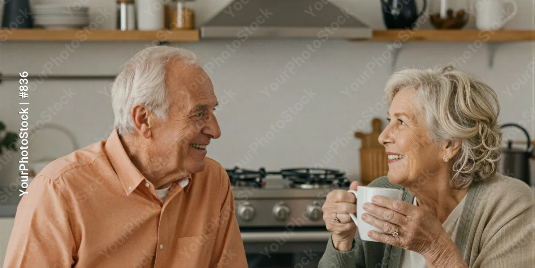 Elderly couple in kitchen chatting over coffee