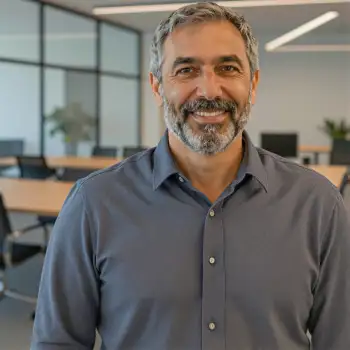 Middle-aged man smiling in modern office beard