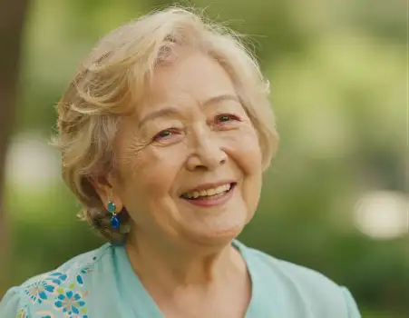 Happy elderly woman smiling in park close-up portrait