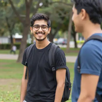 Two young men talking in a park conversation trees university students