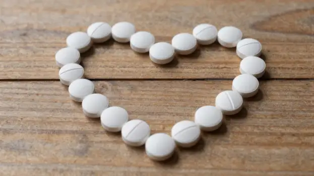 Heart-shaped white Pill Beads on Wooden Table