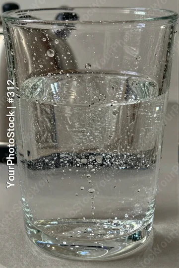 Glass of Water Filled to Brim with Bubbles on Kitchen Countertop