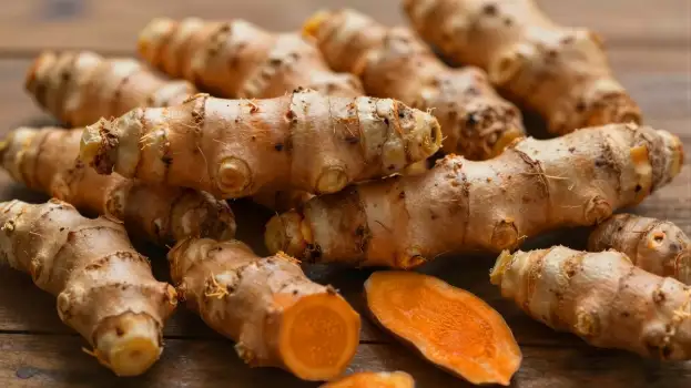 Fresh Turmeric Roots on Wooden Surface food natural health