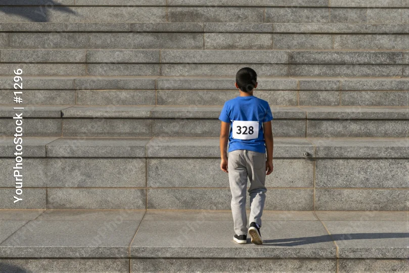 Young Boy Climbing Stairs concrete stairs blue t-shirt