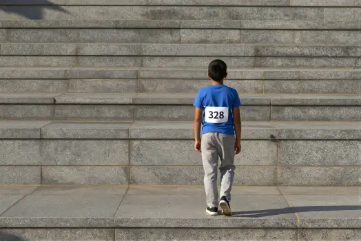 Young Boy Climbing Stairs concrete stairs blue t-shirt