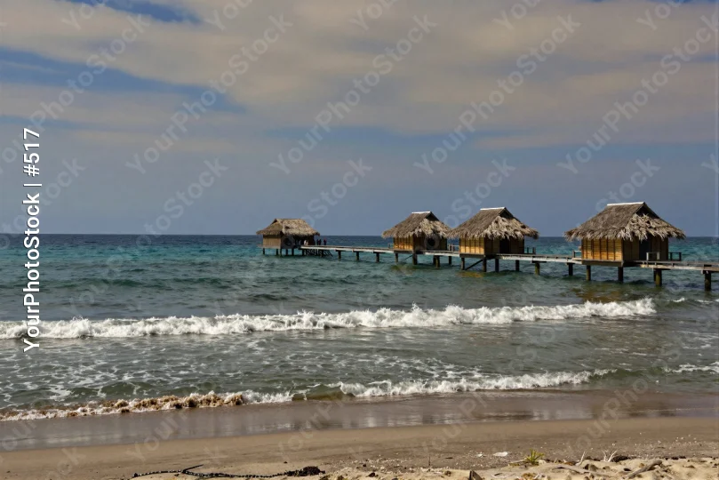Beach with Thatched Huts and Clear Blue Water