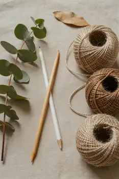 Three Spools of Twine on Beige Background with Wooden Pencils