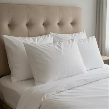 Bedroom with White Sheets and Pillows arranged hotel