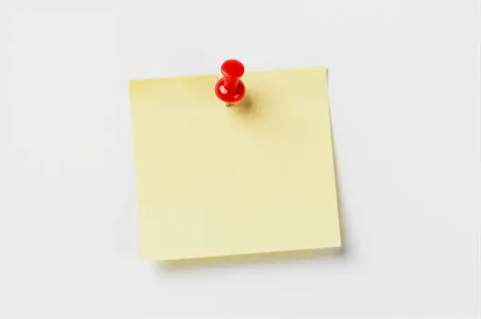 Yellow Sticky Note with Red Pin on White Background