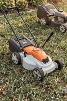 Two Lawn Mowers on Grassy Lawn self-propelled