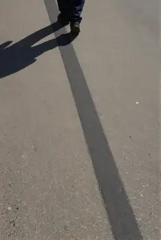Person Walking on Concrete with Long Shadow outdoor