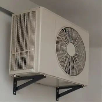 White Air Conditioning Unit with Grid Fan Mounted on Wall Bracket