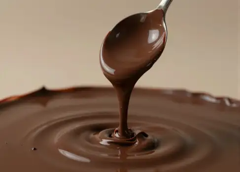 Silver Spoon Full of Melted Chocolate Dripping in Water