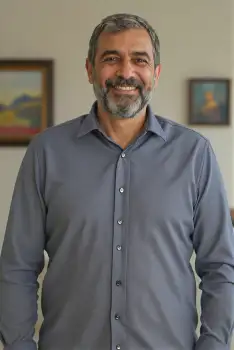 Middle-aged man smiling in office beard mustache business corporate