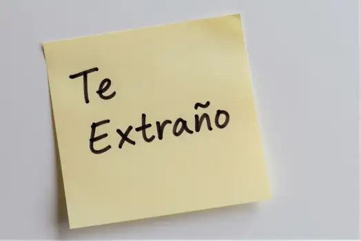 Yellow Sticky Note with 'Te Extraño' Written in Cursive