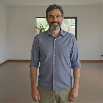 Middle-aged man smiling in an empty room corporate headshot