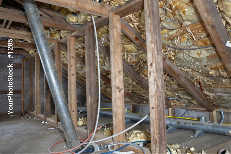 unfinished attic interior with wooden beams and insulation